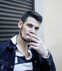 Image showing middle age man smoking cigarette on bacyjard, stylish tough guy, lifestyle people concept 