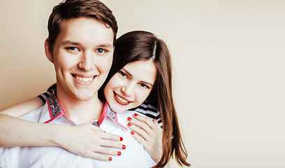 Image showing young pretty teenage couple, hipster guy with his girlfriend happy smiling and hugging isolated on white background, lifestyle people concept 