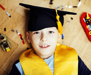 Image showing little cute preschooler boy among toys lego at home education in graduate hat smiling posing emotional, lifestyle people concept 