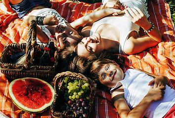 Image showing cute happy family on picnic laying on green grass mother and kids, warm summer vacations close up, brother and sister, lifestyle people concept