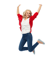 Image showing smiling young woman jumping in air