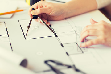 Image showing close up of hands with compass measuring blueprint