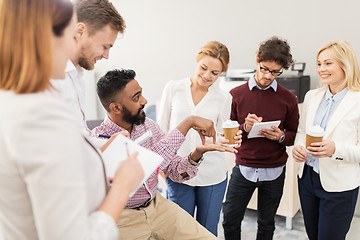 Image showing happy business team with coffee talking at office