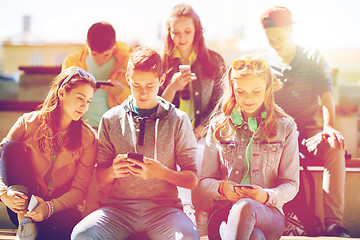 Image showing happy teenage friends with smartphones outdoors