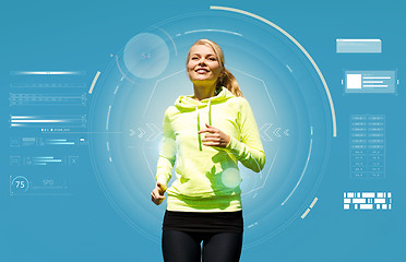 Image showing smiling young woman running over blue background
