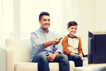 Image showing smiling father and son watching tv at home