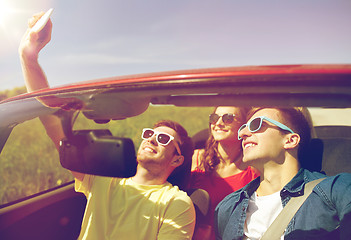 Image showing friends driving in cabriolet car and taking selfie