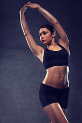 Image showing young woman posing and showing muscles in gym