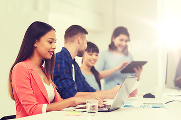 Image showing happy african woman over creative team at office