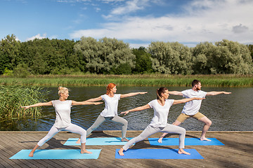 Image showing group of people making yoga exercises outdoors