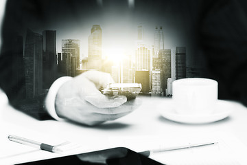 Image showing businessman with smartphone and coffee at office