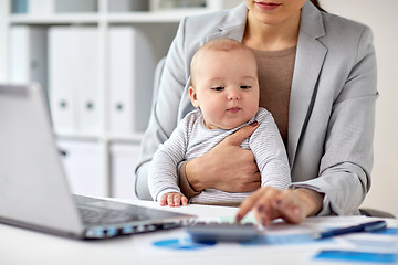 Image showing businesswoman with baby working at office