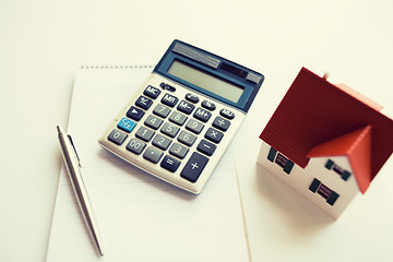 Image showing close up of home model, calculator and notebook