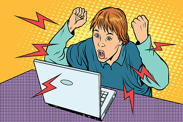 Image showing Angry teenager sitting at computer laptop