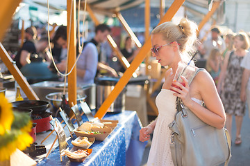 Image showing Woman buying meal at street food festival.