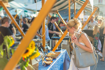 Image showing Woman buying meal at street food festival.