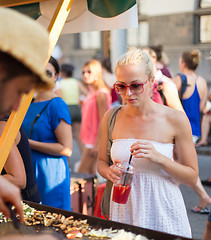 Image showing Woman buying meal at street food festival.