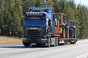 Image showing Black Scania R520 Hauls Machinery along Road