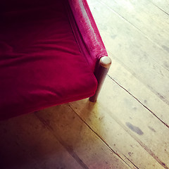 Image showing Vintage red velvet armchair on wooden floor