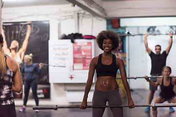 Image showing black woman lifting empty bar