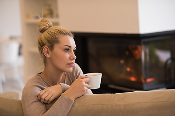 Image showing woman with a mug near a fireplace