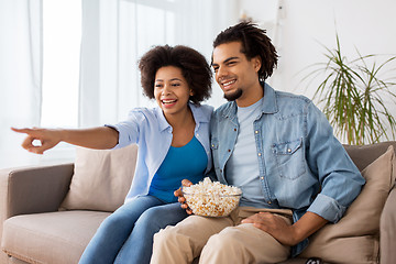 Image showing smiling couple with popcorn watching tv at home