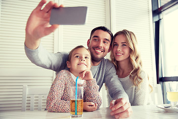 Image showing happy family taking selfie at restaurant