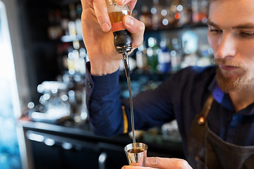 Image showing barman with shaker preparing cocktail at bar