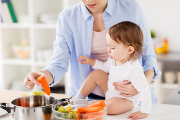 Image showing happy mother and baby cooking vegetables at home