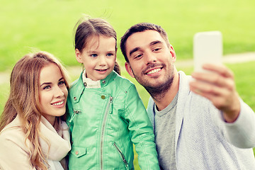 Image showing happy family taking selfie by smartphone outdoors