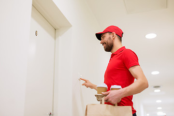 Image showing delivery man with coffee and food ringing doorbell