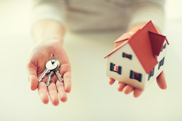Image showing close up of hands holding house model and keys