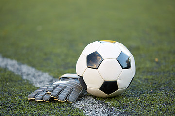 Image showing soccer ball and goalkeeper gloves on field