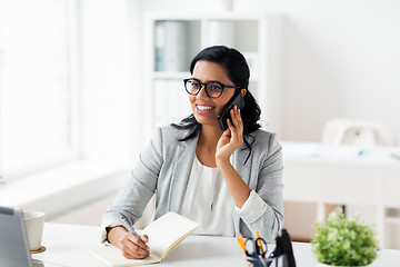 Image showing businesswoman calling on smartphone at office