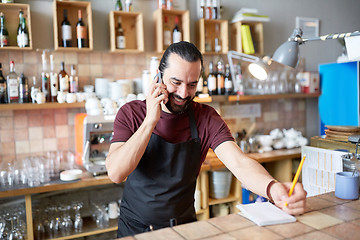 Image showing happy man or waiter at bar calling on smartphone