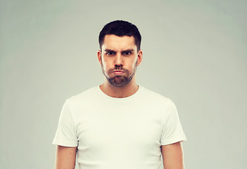 Image showing man with funny angry face over gray background