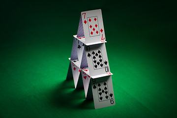 Image showing house of playing cards on green table cloth