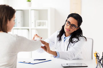 Image showing doctor examining patient hand at hospital