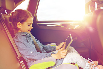 Image showing happy little girl with tablet pc driving in car