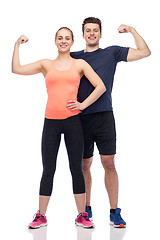 Image showing happy sportive man and woman showing biceps power