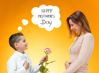 Image showing Young kid giving red rose to his mom