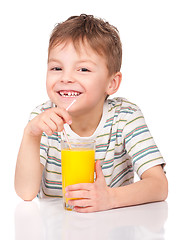 Image showing Little boy drinking orange juice