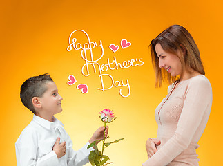 Image showing Young kid giving red rose to his mom