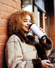 Image showing young pretty african american women drinking coffee outside in cafe, modern real business woman lifestyle concept