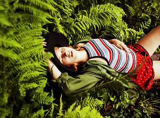 Image showing Pretty young blond girl hipster in hat among fern, vacation in green forest 