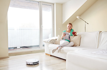 Image showing happy woman and robot vacuum cleaner at home