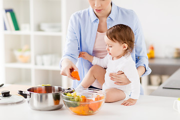 Image showing happy mother and baby cooking vegetables at home