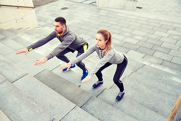 Image showing couple doing squats on city street stairs