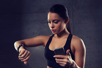 Image showing woman with heart-rate watch and smartphone in gym