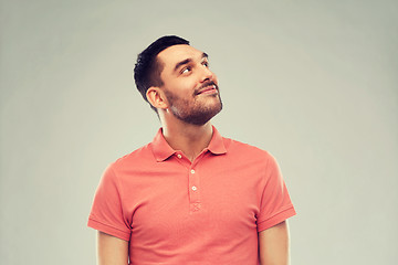 Image showing smiling man looking up over gray background